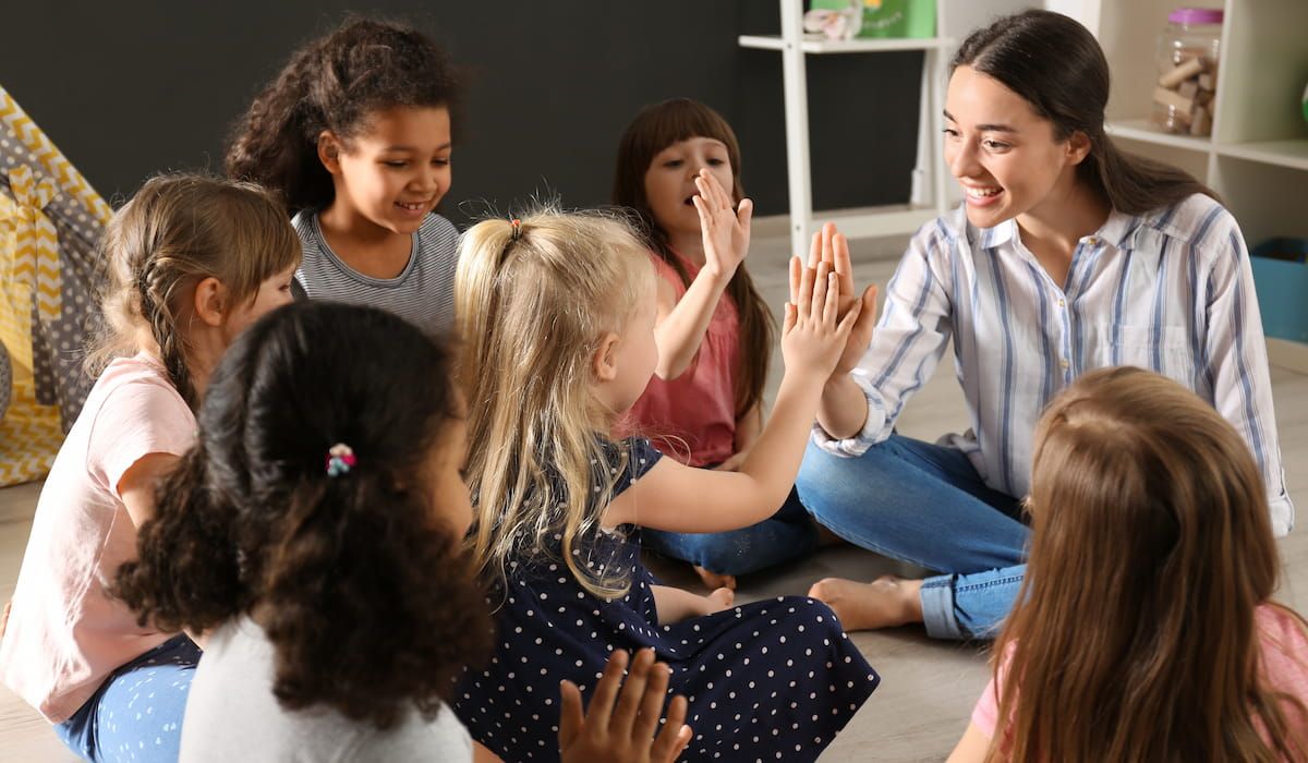 nursery teacher teaching kids at home