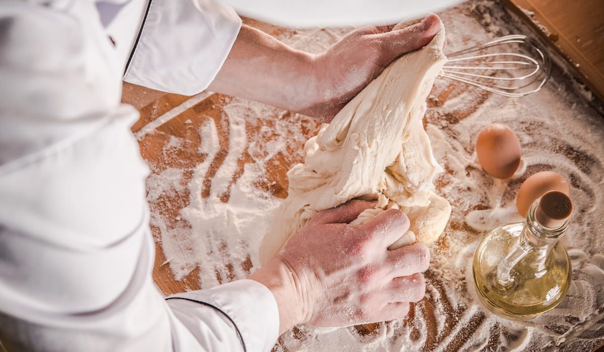 baker making fresh bread dough