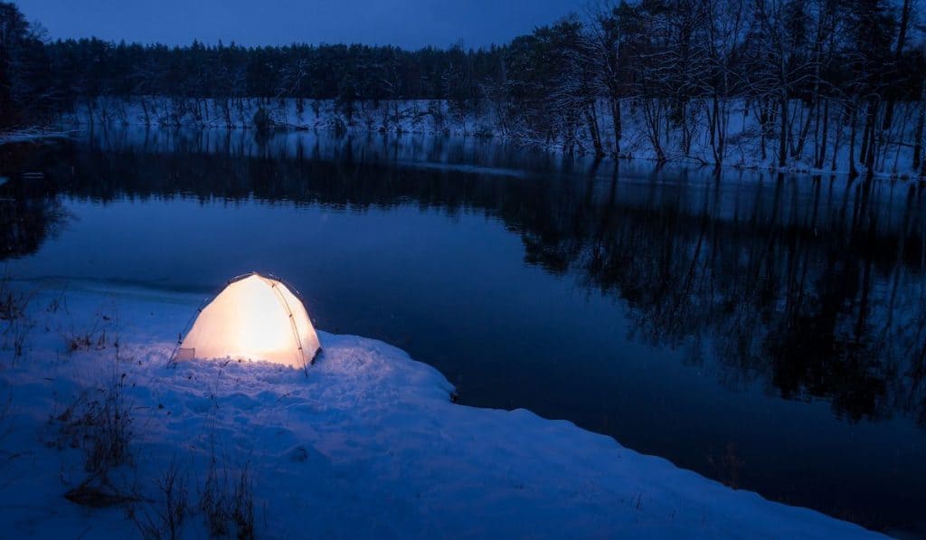 a light inside a tent on a freezing winter night