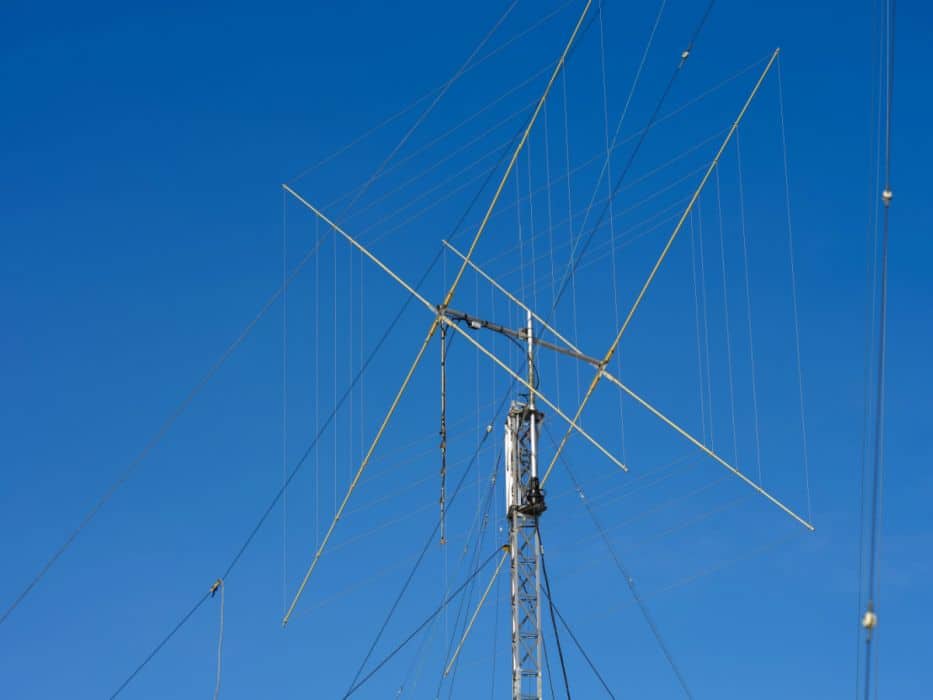 a tall ham radio antenna under the clear blue sky