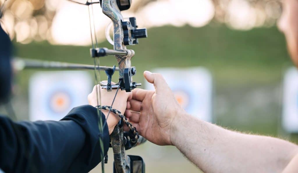 archery coach teaching student archery