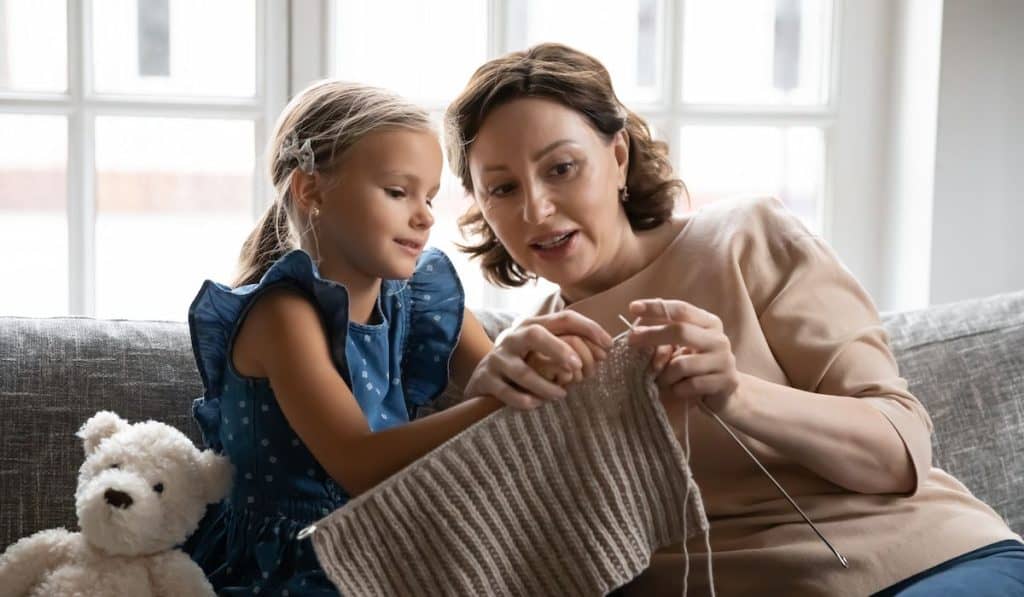 mother teaching daughter how to weave