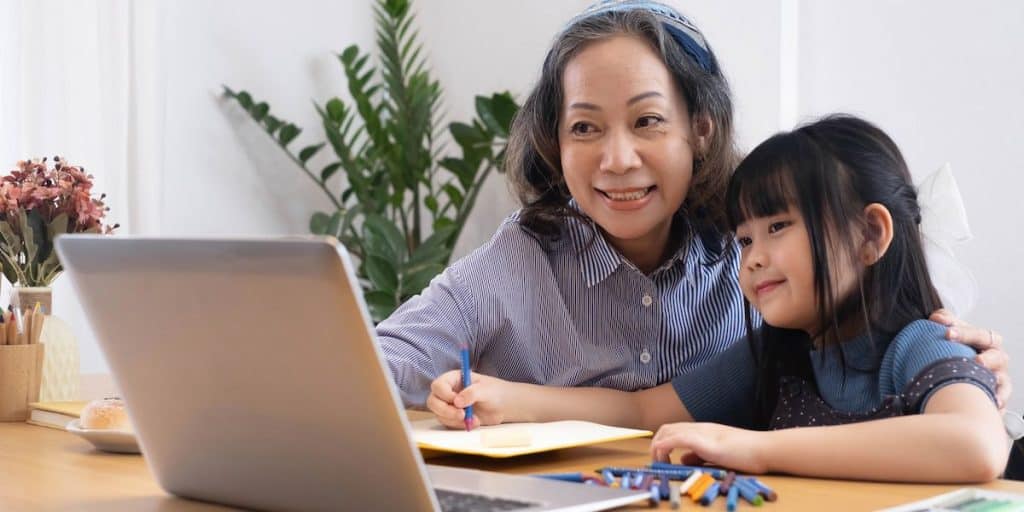 woman in 50s teaching her granddaughter at home 