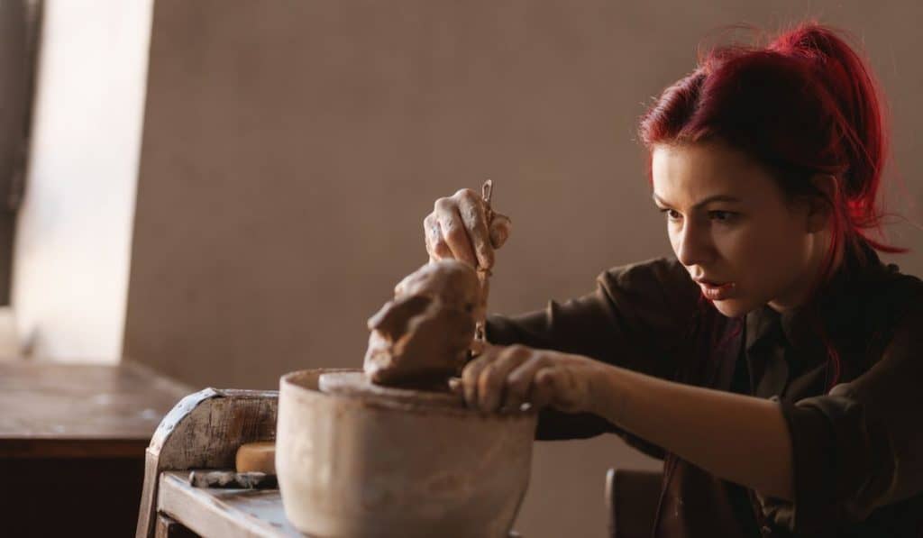 woman sculptor creating a clay figure