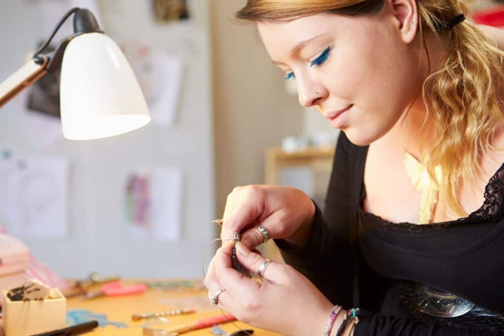 a young woman making a jewelry inside her room