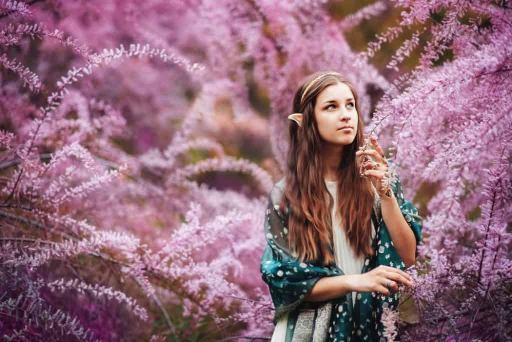 cosplay of a teenage girl portraying an elf in a mystical forest 