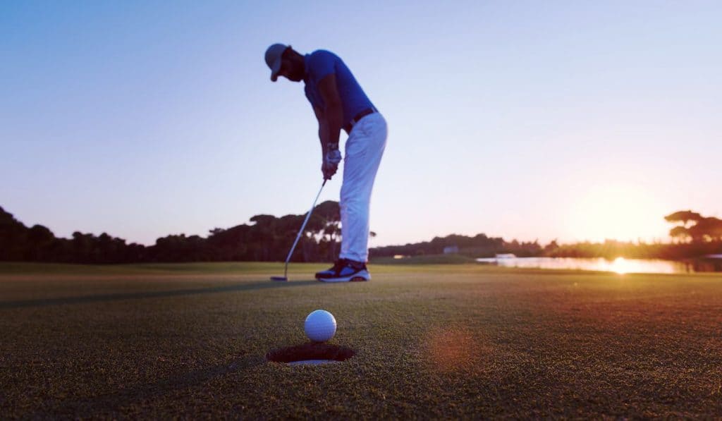 golfer putting on sunset