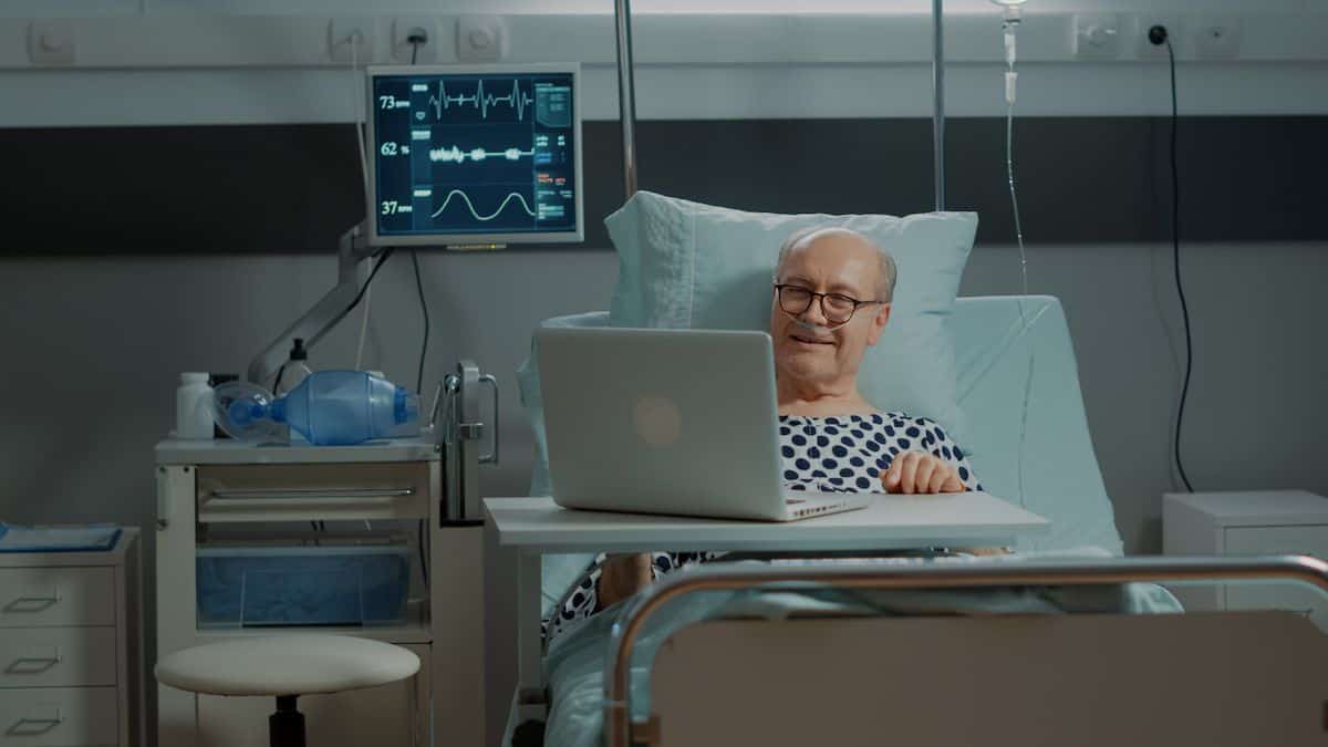 long term patient using laptop while in hospital bed