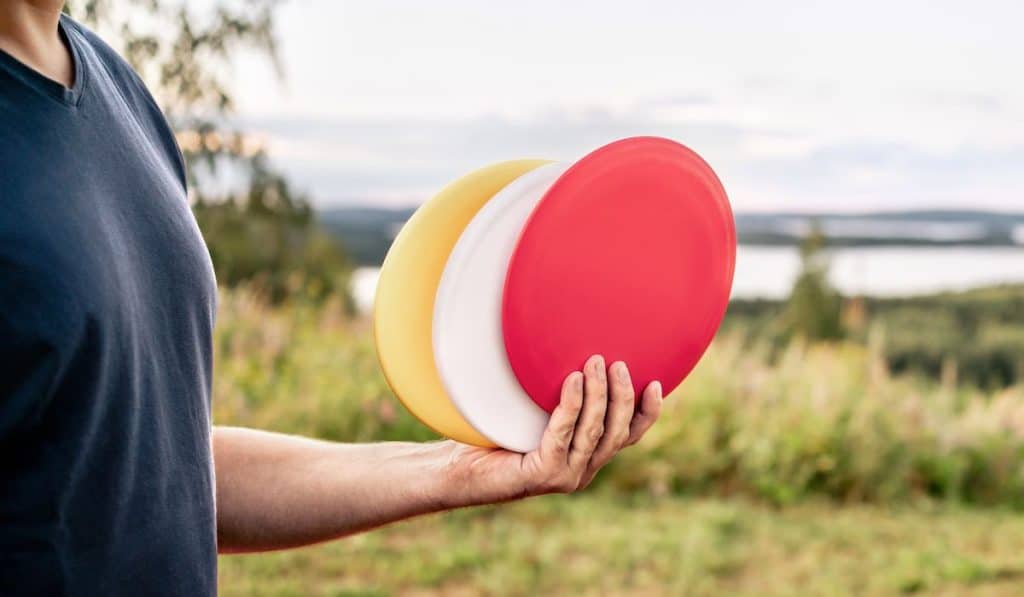 three different golf discs on hand