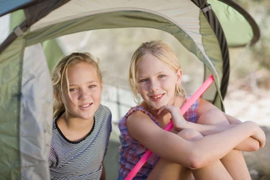 two pretty girls smiling inside the tent