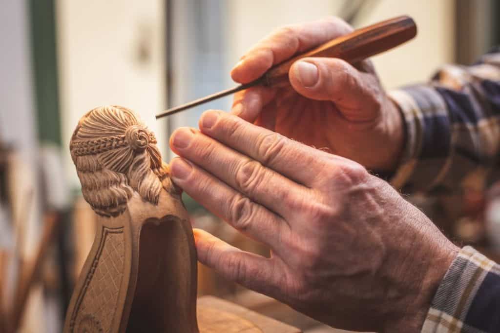 a man holding a chisel doing wood carving