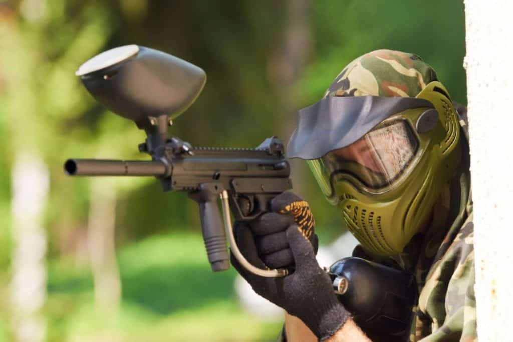 a man in helmet holding a paintball gun