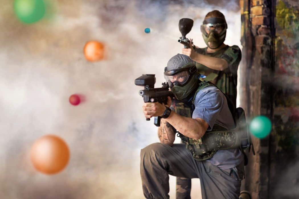 two players aiming their paintball guns