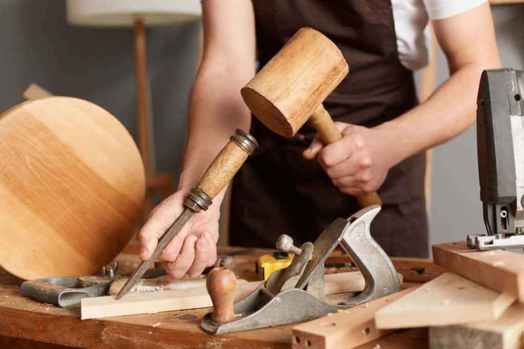 using a round wood carving mallet in a workshop