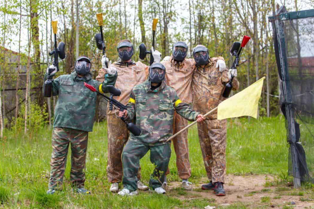 Team of five men in full gear won capture the flag game in paintball