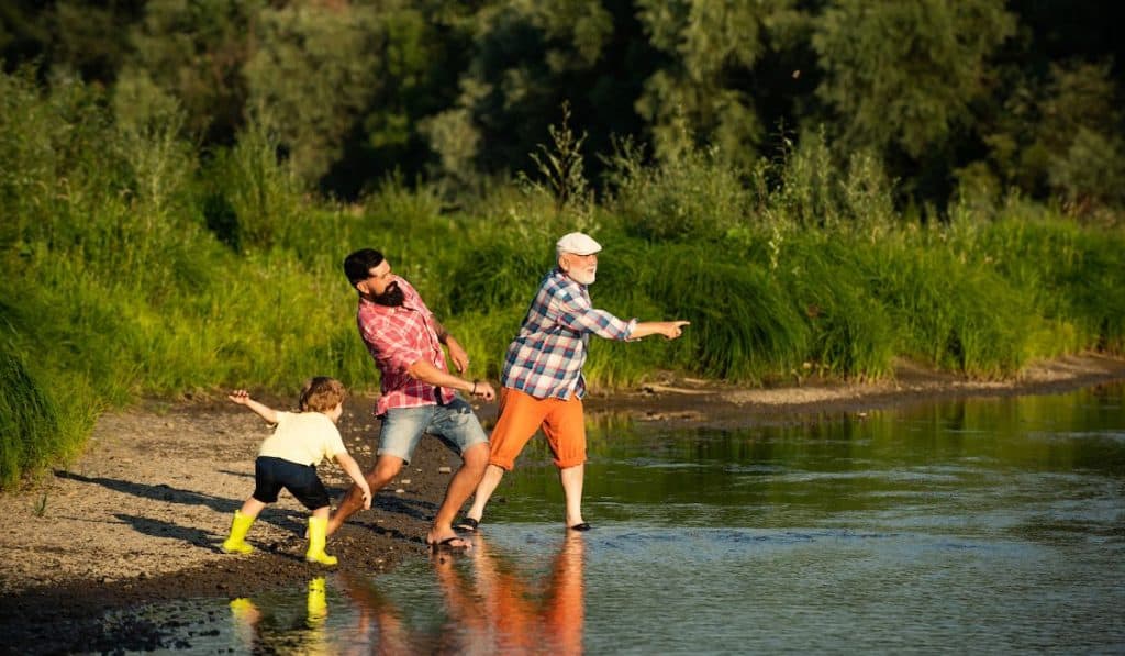 grandpa, dad and son stone skipping