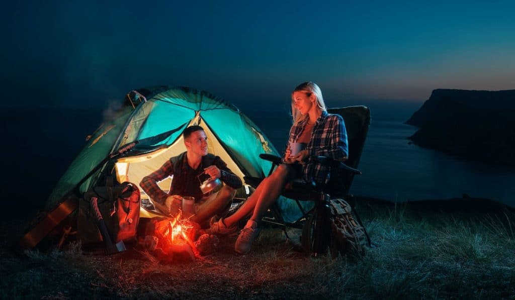 young couple camping at night