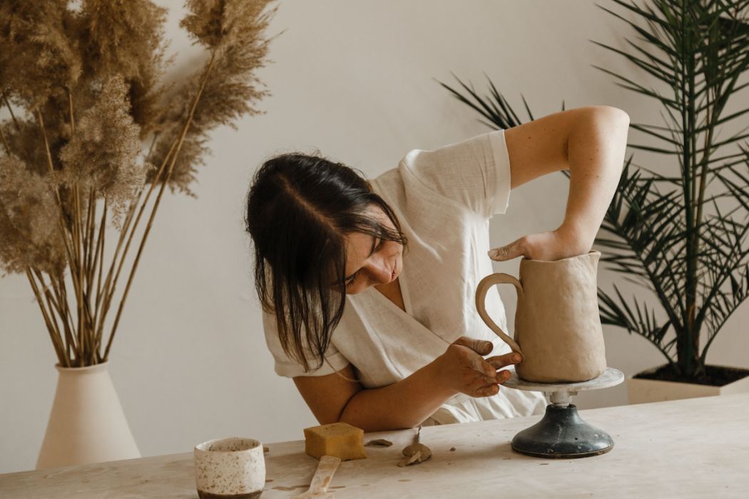 Female ceramist hands sculpt clay dishes