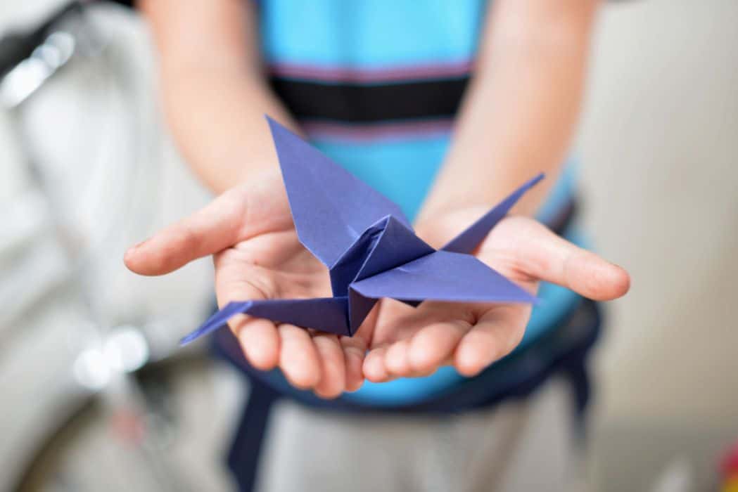 paper folded crane on the child's hand