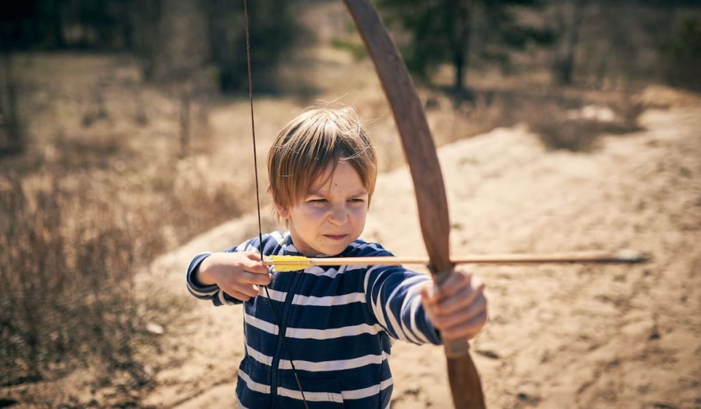 little boy practice to shoots a bow 