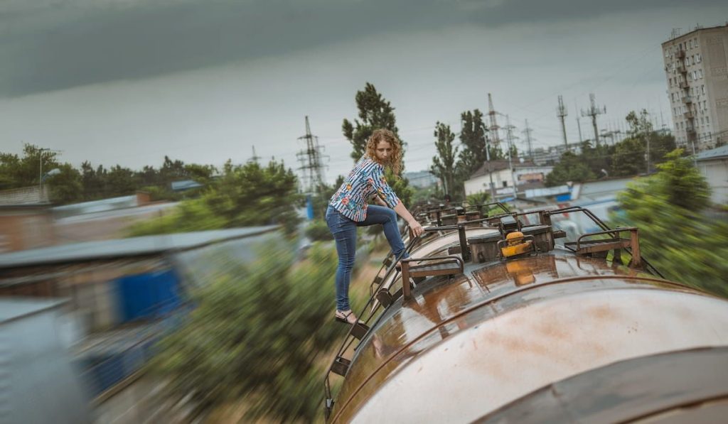 girl climbs onto the roof of a freight train 