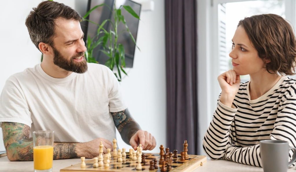 young couple playing chess at home