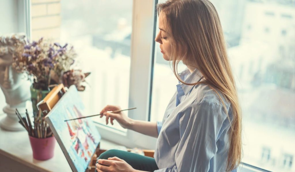 woman painting by her window