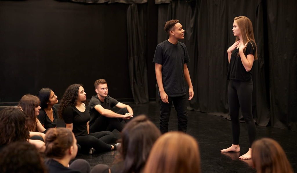 aspiring actors in an acting class performing