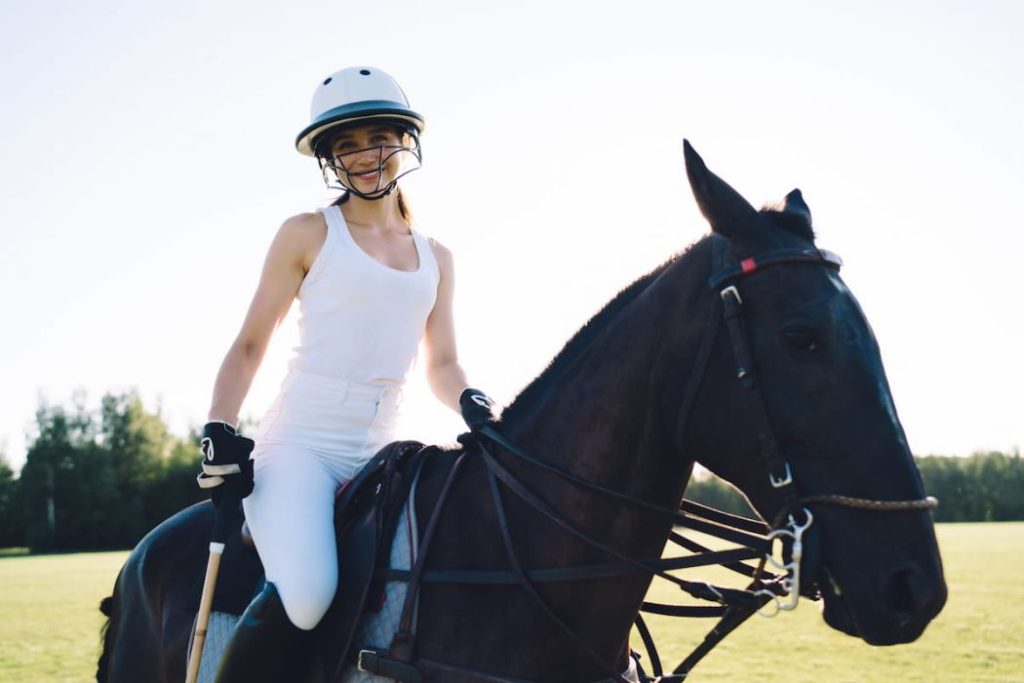 female equestrian in helmet horse back riding