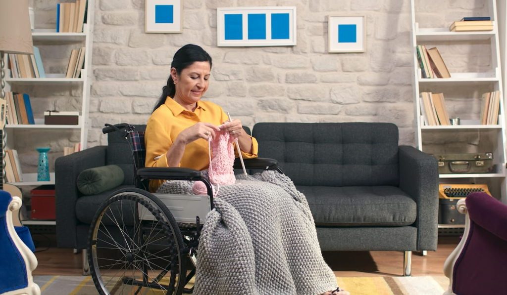lady knitting handmade scarf on her wheelchair