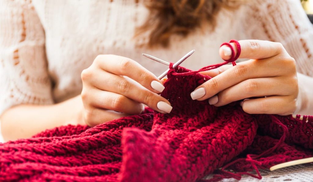  woman knitting a red sweater