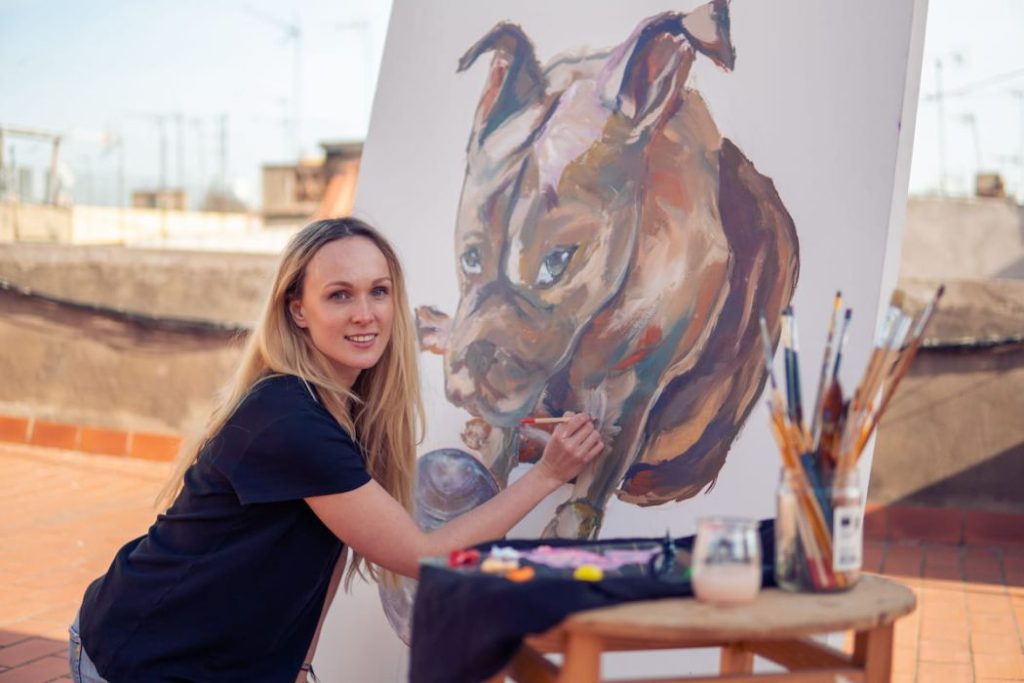 female artist painting a dog at the roof top