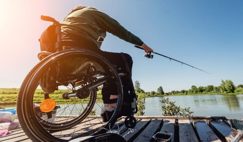 young disabled man in a wheelchair fishing 