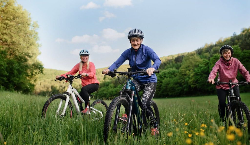 three senior girlfriends cycling together