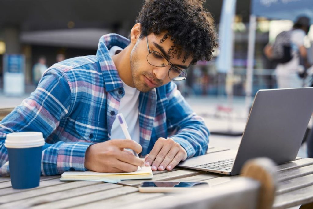 student writing notes on his journal, trying to learn a new language