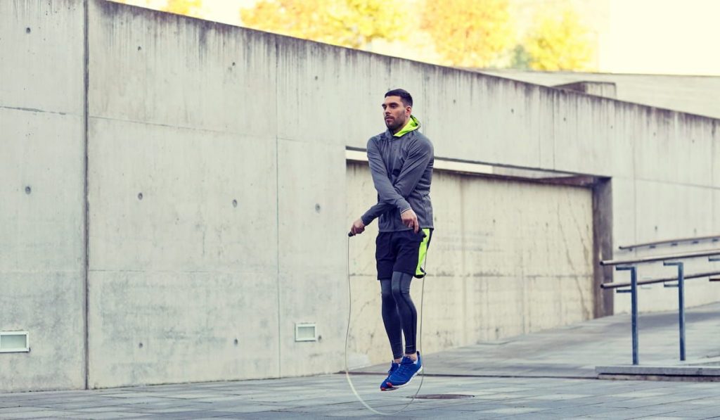 man exercising with jump-rope outdoors 