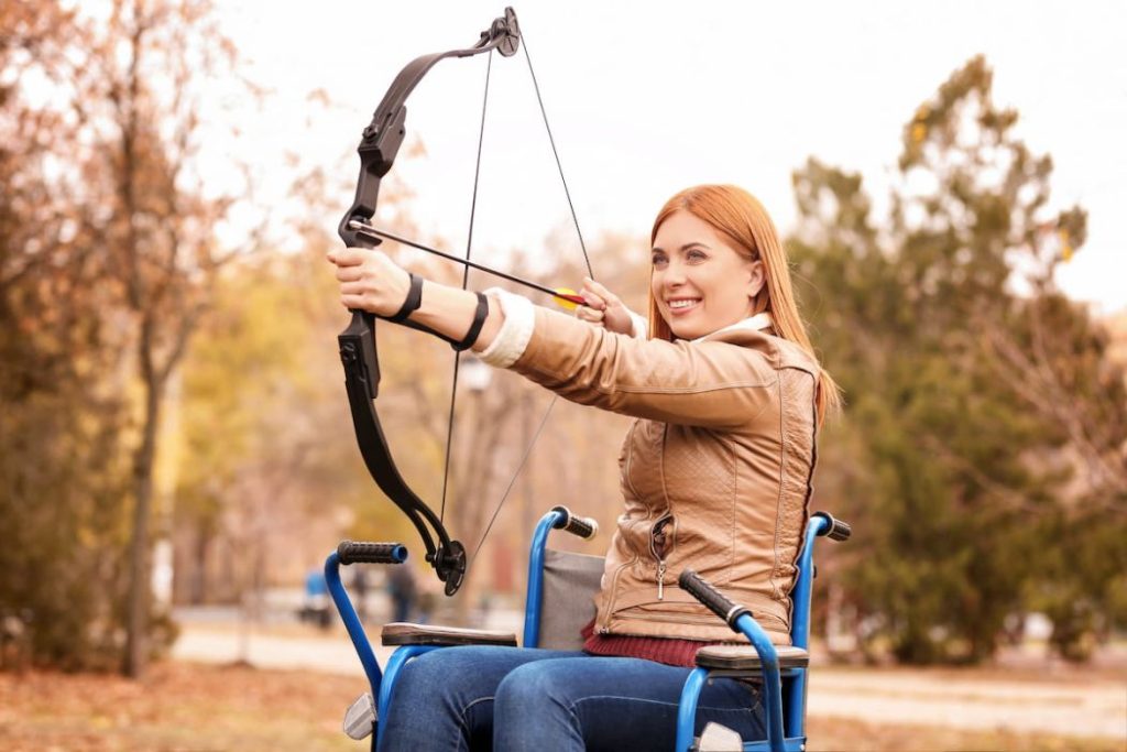 woman in wheelchair practicing archery