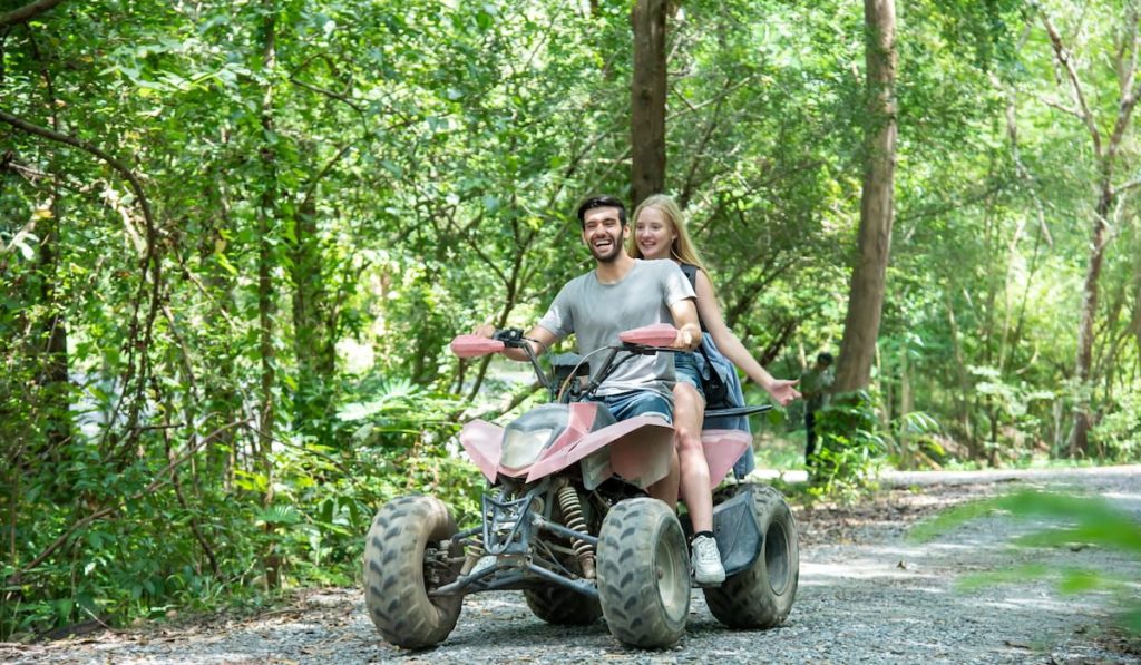 young couple ride ATV on travel adventure 