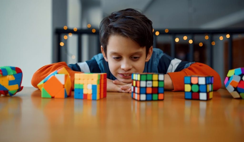 Little boy looking at puzzle cubes 