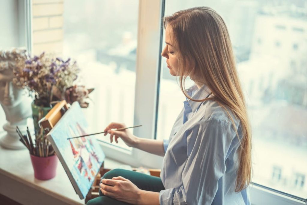 woman painting by her window