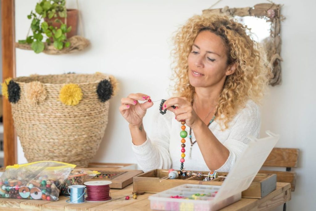 woman making handmade jewelry at home