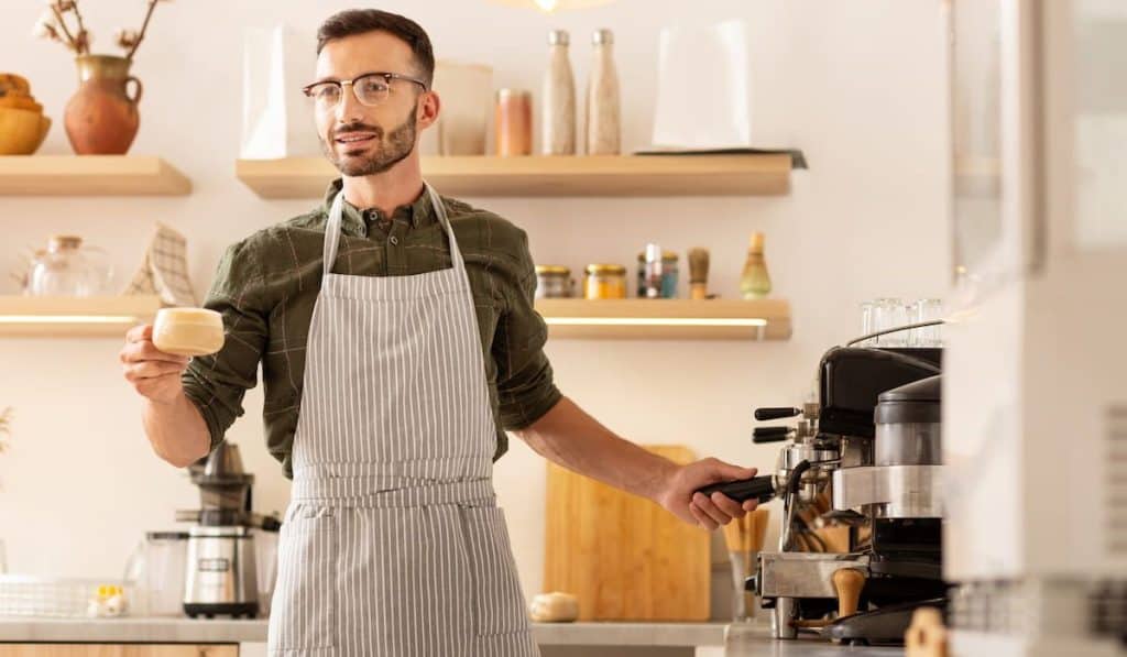 Businessman making coffee in his own cafeteria