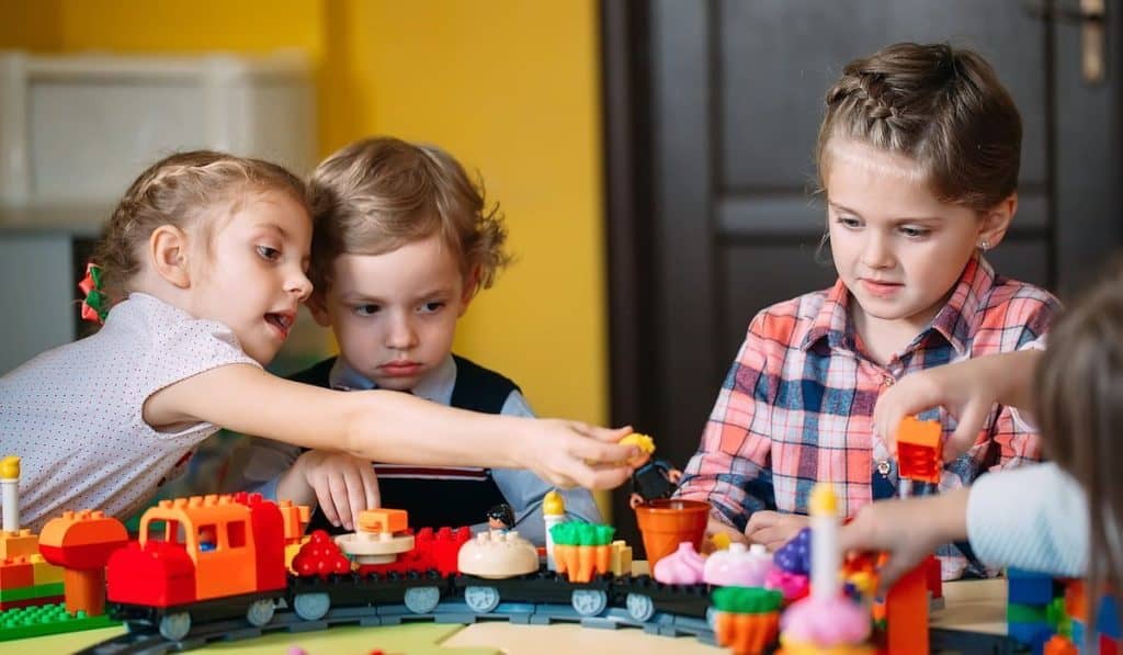 Child playing with constructor lego blocks at class