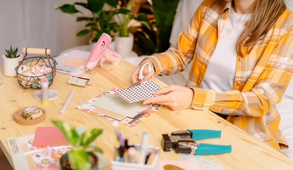 Cropped shot of women making homemade scrapbooking album from paper. 