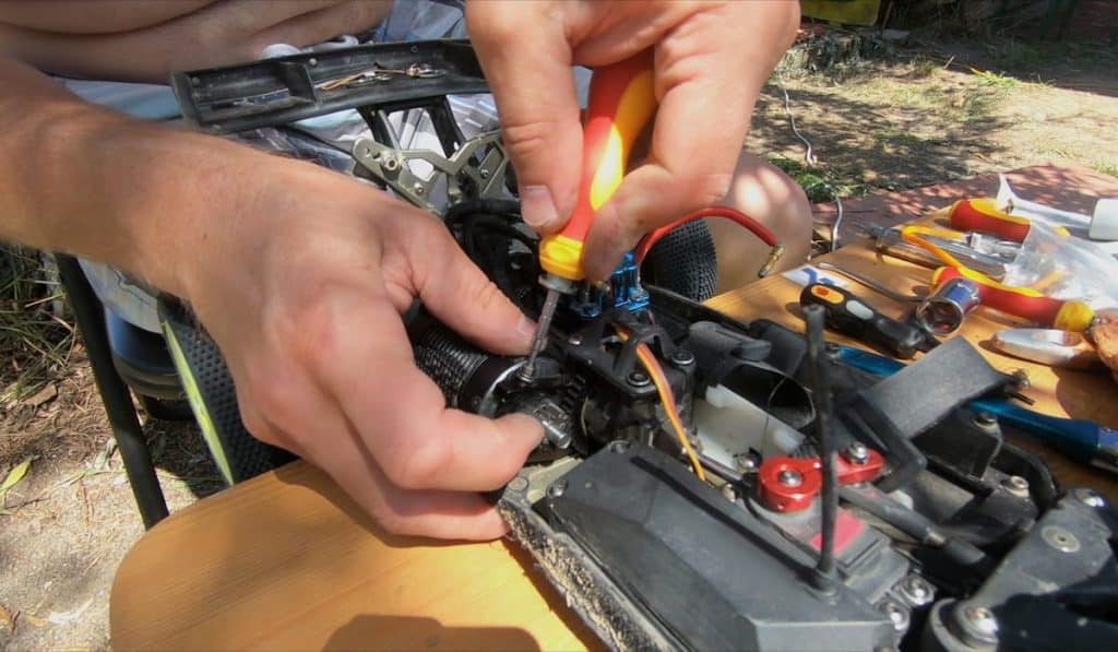 Man's hands screwing screw in a remote car 