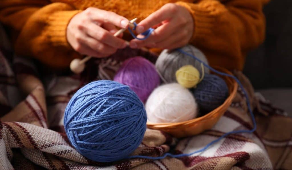 Woman knits sitting on sofa