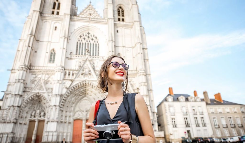 Young woman tourist walking with photo camera