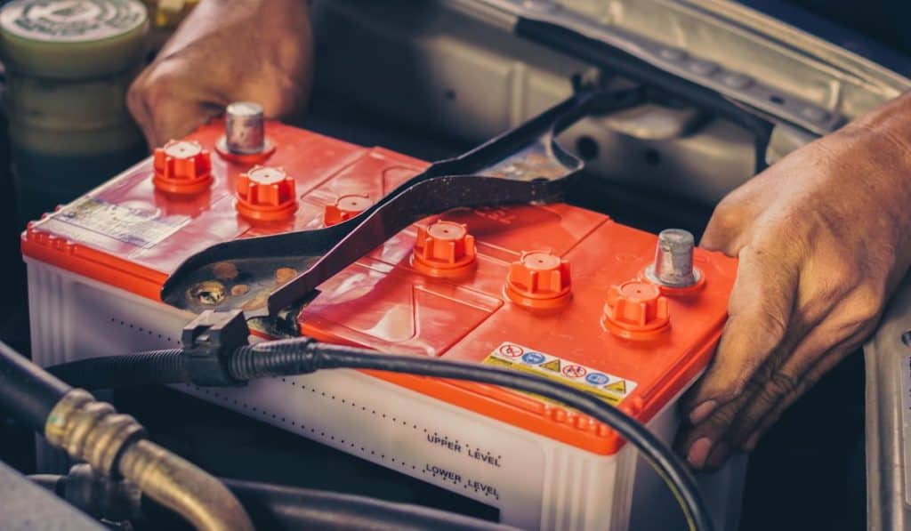 A car mechanic replaces a battery