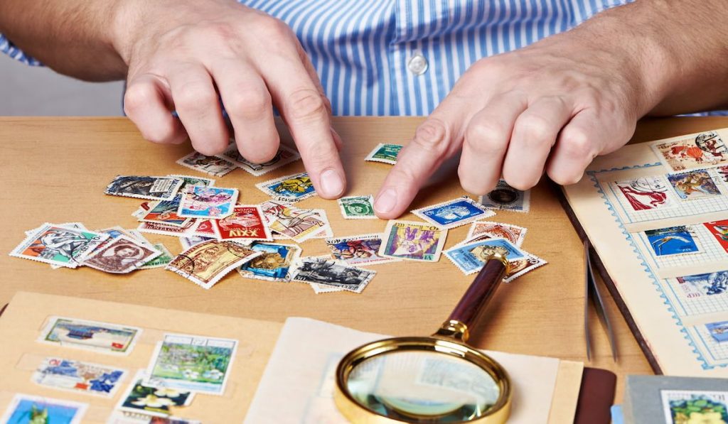 Man watching a collection of postage stamps