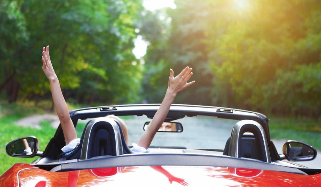 a woman driving a car going to nowhere